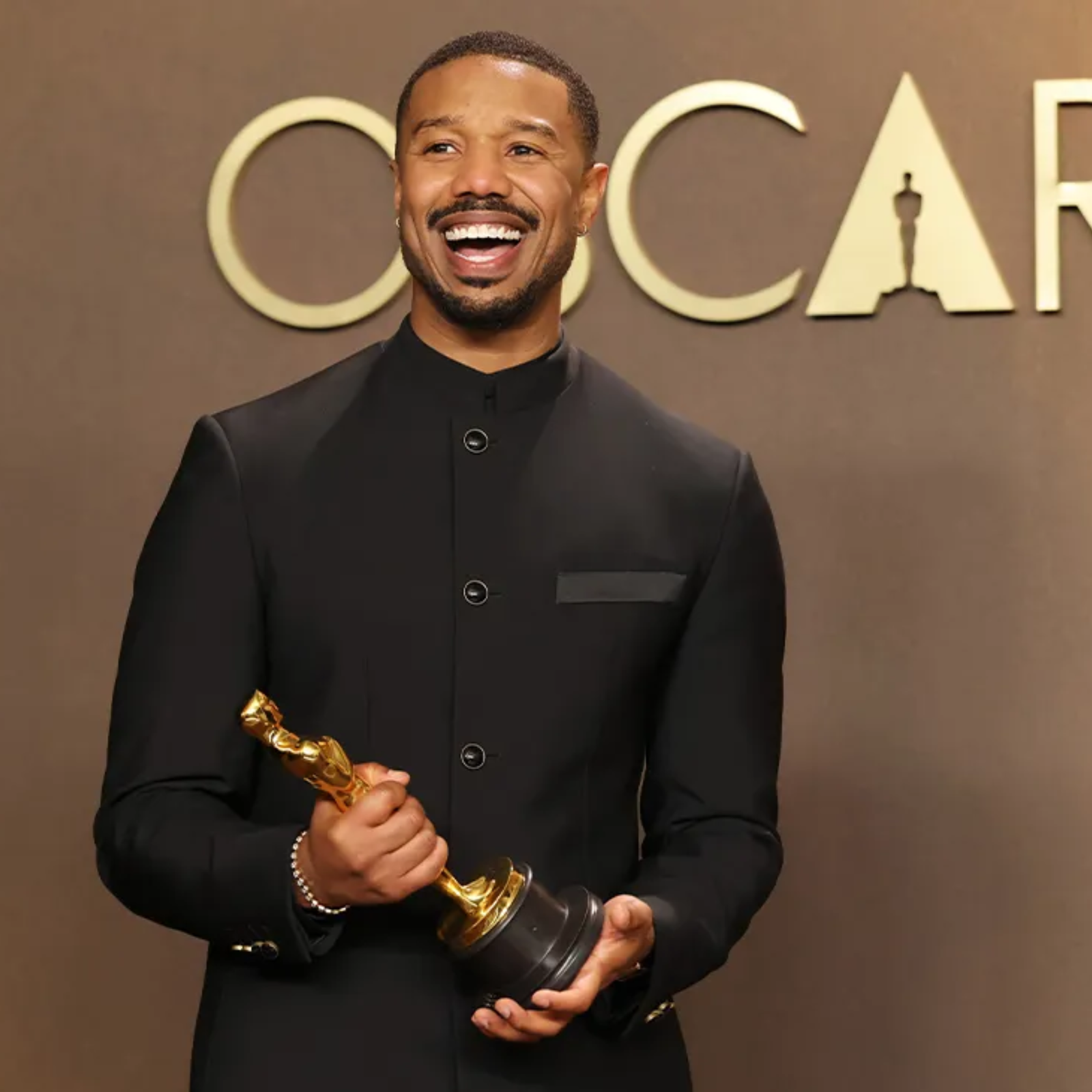 Michael B. Jordan sonriendo con su premio Óscar a Mejor Actor