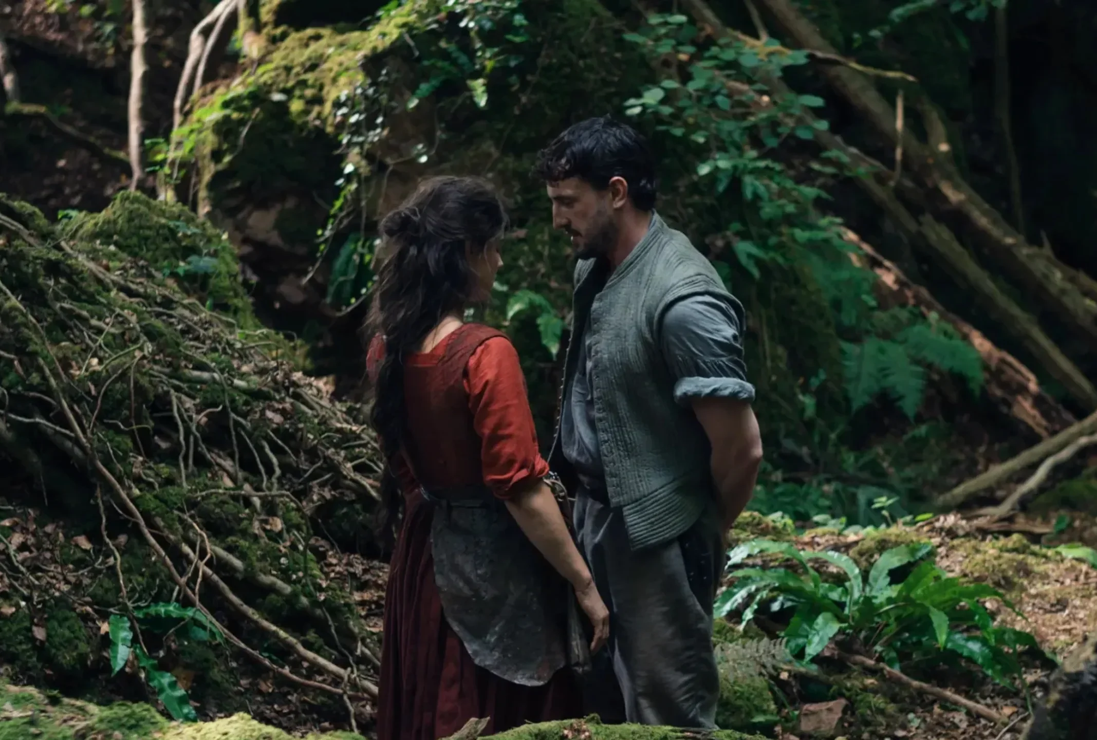Escena de la película Hamnet (2026) en un bosque frondoso con vestimenta de época