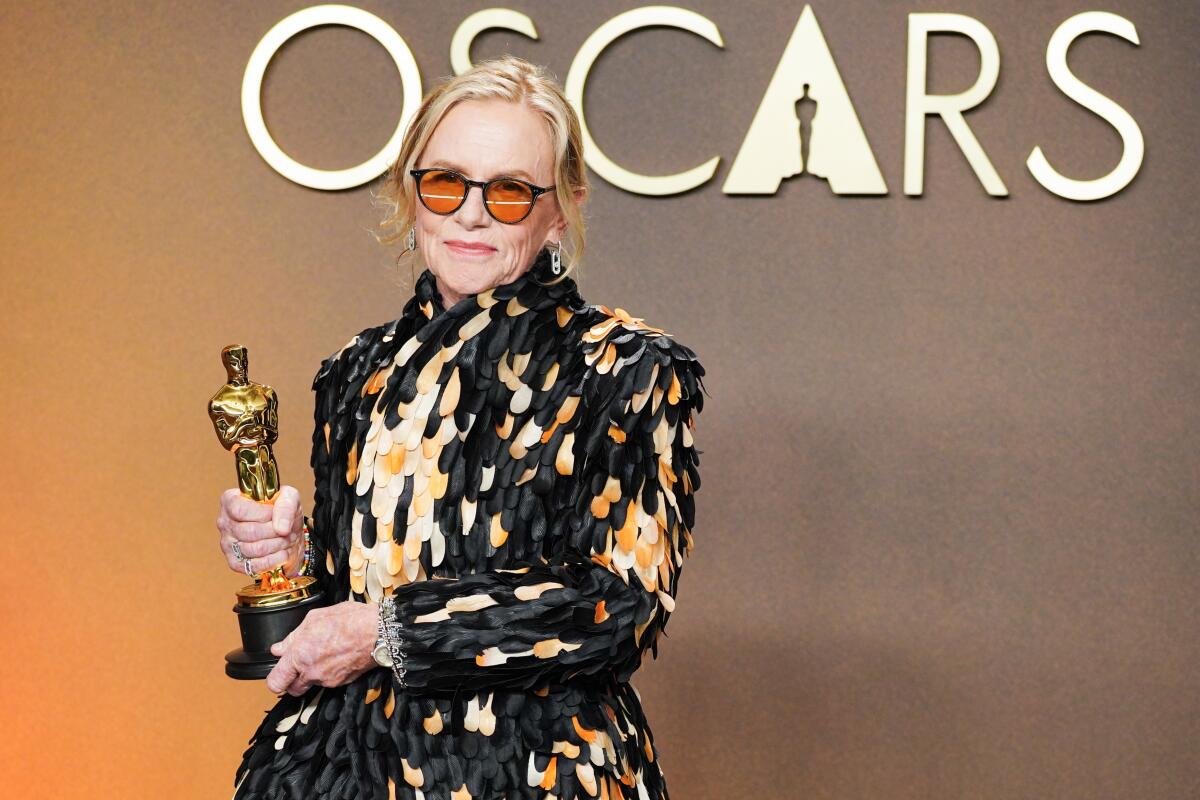 Amy Madigan posando con la estatuilla dorada para la prensa tras su victoria en los Óscar 2026, con una sonrisa tranquila
