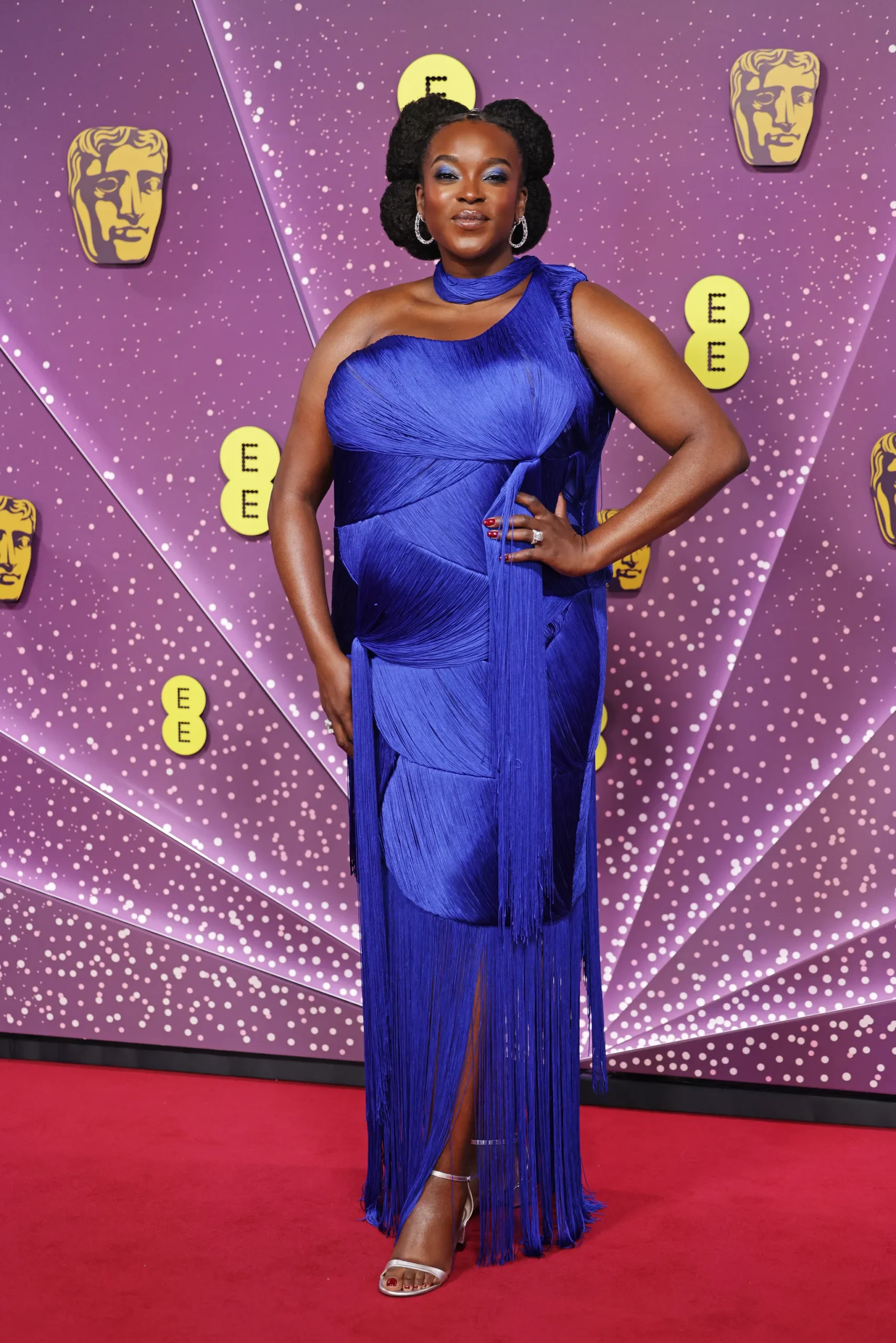 Wunmi Mosaku en la alfombra roja de los premios BAFTA luciendo un vibrante vestido azul